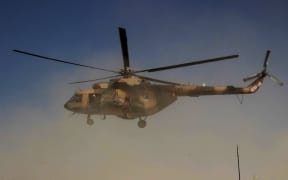 An Afghan helicopter carrying security personnel arrives at the scene of an offensive against Taliban insurgents in Kunduz on 30 September.
