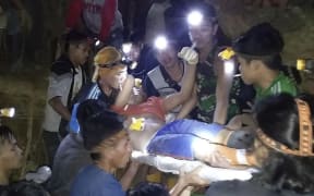 In this undated photo released by Indonesian Search And Rescue Agency (BASARNAS) rescuers evacuate a survivor from a collapsed gold mine in Bolaang Mongondow, North Sulawesi, Indonesia.