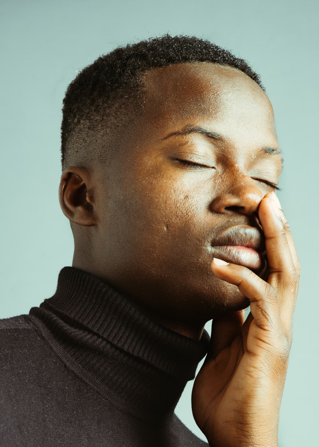 black man touching his face