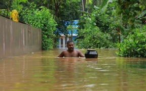 A man walks in flood waters at Eloor area in Ernakulam district, in the south Indian state of Kerala.