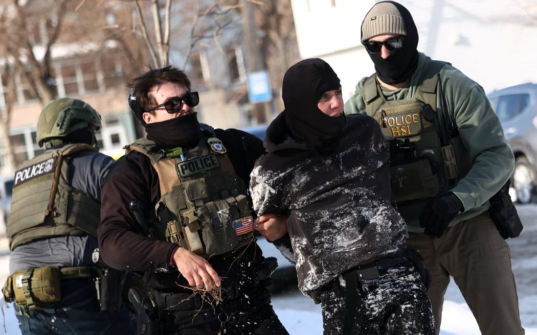 Federal agents detain a protester in Minneapolis, Minnesota on February 3, 2026. A US judge on January 31, 2026 denied Minnesota's bid to force Immigration and Customs Enforcement (ICE) to suspend its sweeping detention and deportation operation in the state that has left two US citizens dead and fueled massive protests. Masked and heavily armed federal agents have swept through Minnesota communities seeking undocumented migrants, detaining thousands and shooting dead two US citizens in the process. (Photo by Charly TRIBALLEAU / AFP) / ALTERNATE CROP