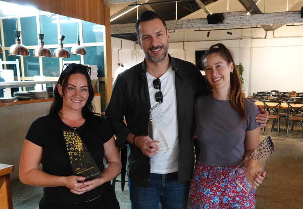 Peekaboo Backyard Eatery owner Daniel Fasnacht with partner Carolyn Dando (right) and duty manager Kayla Parker (left), with the café’s swag of awards.