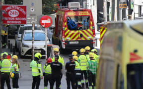 Police and emergency service workers gather near the site of a building collapse in Madrid on 7 October, 2025. Spanish emergency services scrambled to a building collapse in Madrid's touristic city centre on Tuesday with local media reporting several people missing. Emergency services said on X that firefighters were working at the scene of a building undergoing refurbishment near the Spanish capital's opera.