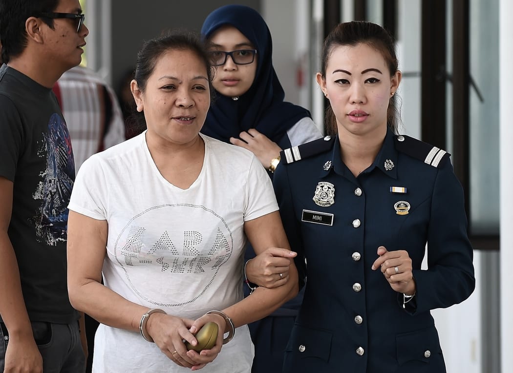 Australian woman Maria Elvira Pinto Exposto (L) is escorted by Malaysian customs officials as she arrives at the Magistrate Court in Sepang on March 26, 2015. The case of an Australian woman facing a possible death sentence for drug trafficking in Malaysia was delayed again on March 26.