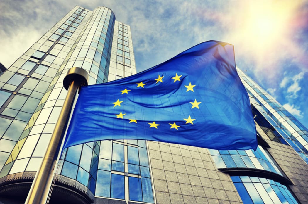 EU flag waving in front of European Parliament building. Brussels, Belgium