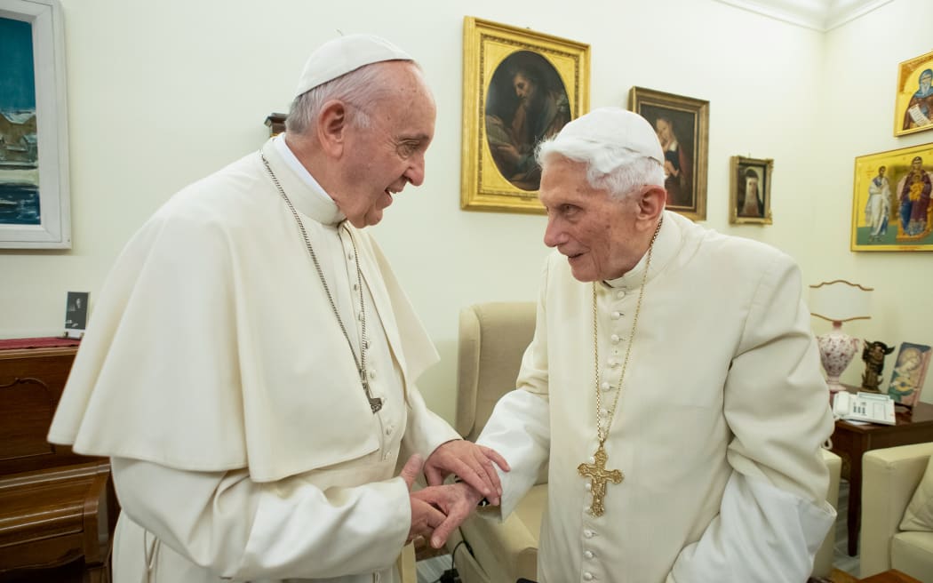 (FILES) This file handout picture taken and released by Vatican Media on December 21, 2018, shows Pope Francis (L) meeting with Pope Benedict XVI (R) at the Vatican.