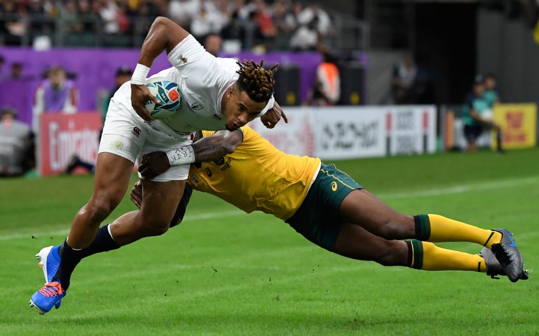 England's wing Anthony Watson (L) is tackled during the Japan 2019 Rugby World Cup quarter-final match between England and Australia at the Oita Stadium in Oita on October 19, 2019. (Photo by CHRISTOPHE SIMON / AFP)
