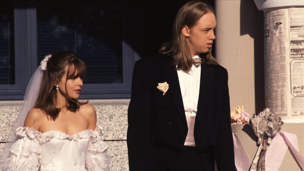 Rachel McKenna and Nick Harrison on their wedding day. Rachel is in a white wedding dress. Nick wears a tuxedo.