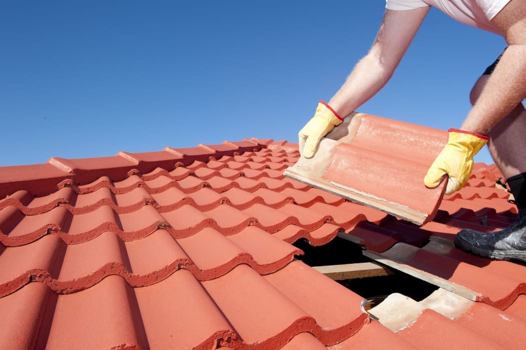 A man fixing a roof.