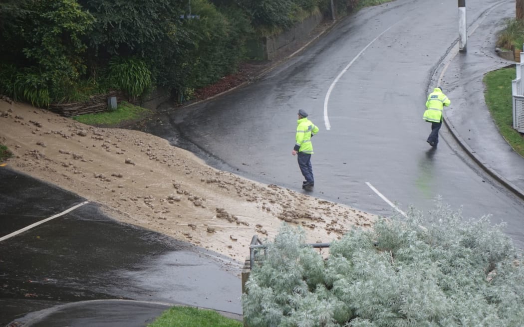 A torrent of mud is coming from a driveway on corner of Ravenswood Road and Cliffs Road, St Clair. Police have evacuated a number of houses around a bank that is at risk of collapse. Other families are leaving the area.