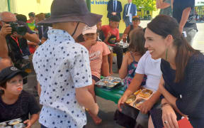 Prime Minister Jacinda Ardern talks to students receiving a free lunch at Flaxmere Primary School.