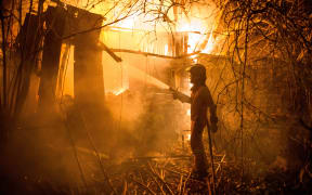 A firefighter battles a wild fire in Carrio, northwest Spain.