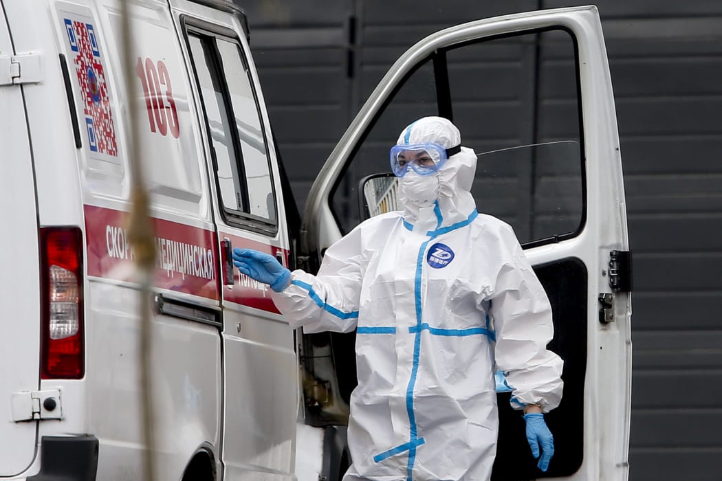 Patients suspected of Covid-19 infection are brought by health officials wearing protective gear with ambulances to Kommunarka Hospital in Moscow, Russia