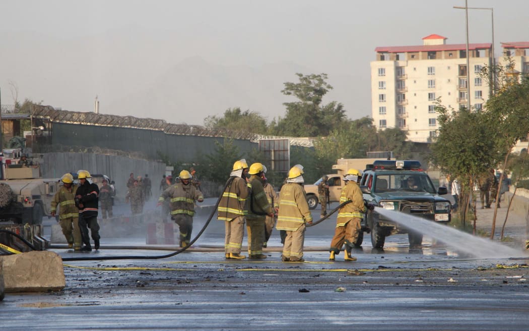 Firefighters clear debris after double suicide attacks killed at least 24 people in Kabul outside the Defence Ministry.