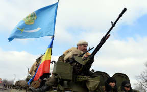 Armed pro-Russian rebels ride an Armoured Personnel Carrier in the eastern Ukrainian city of Debaltseve.