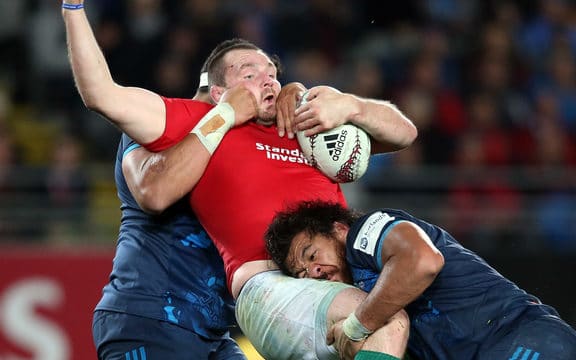 British and Irish Lions captain Ken Owens (C) is tackled by Blues' Alex Hodgman (L) and Steven Luatua (R) during the rugby match between The British and Irish Lions and Auckland Blues at Eden Park.