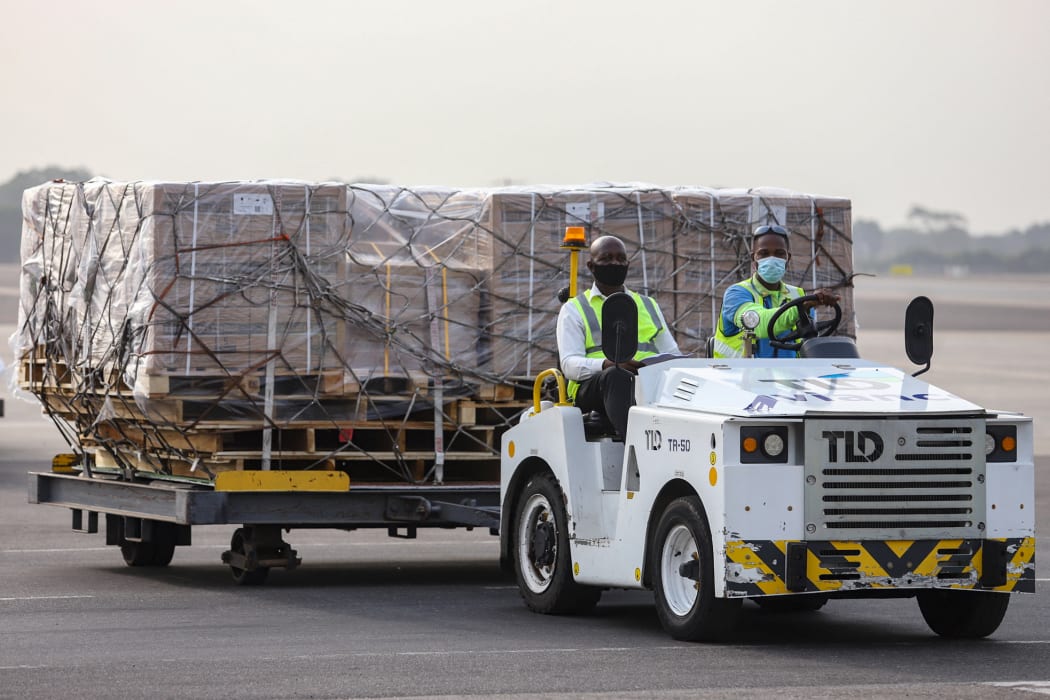 Airport workers transport on dollies a shipment of Covid-19 vaccines from the Covax global Covid-19 vaccination programme, at the Kotoka International Airport in Accra.
