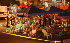 Police investigators collect evidence through injured and dead people lying on the ground, at the site of an explosion at a night market in Davao City, in southern island of Mindanao.