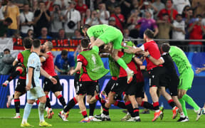 Georgia's players around goalkeeper Giorgi Mamardashvili celebrate after their victory over Portugal at Euro 2024.