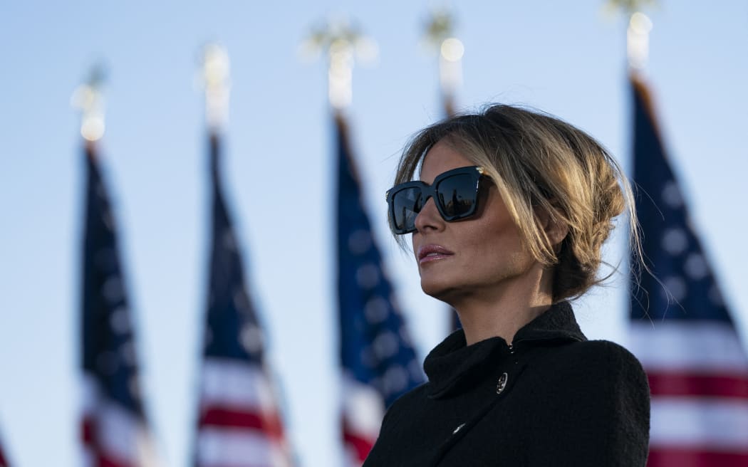 Outgoing First Lady Melania Trump listens as her husband Outgoing US President Donald Trump addresses guests at Joint Base Andrews in Maryland on January 20, 2021. President Trump and the First Lady travel to their Mar-a-Lago golf club residence in Palm Beach, Florida, and will not attend the inauguration for President-elect Joe Biden. (Photo by ALEX EDELMAN / AFP)