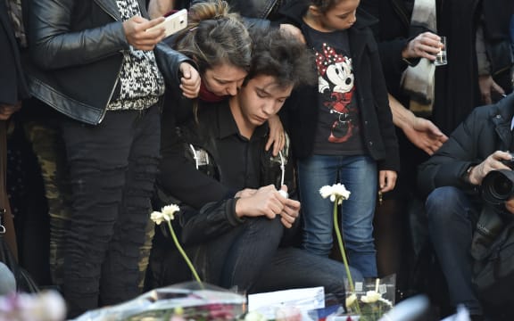 People gather at a makeshift memorial in front of Le Carillon restaurant,  one of the sites of the attacks in Paris.