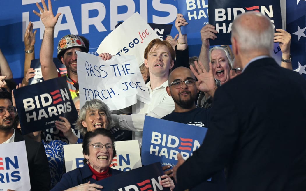 A supporter of US President Joe Biden holds a sign that read "Pass the torch Joe" during a campaign event in Madison, Wisconsin, on July 5, 2024. (Photo by SAUL LOEB / AFP)