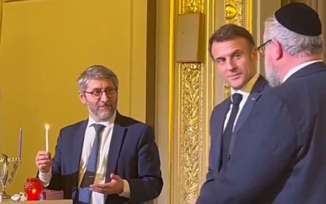President Emmanuel Macron looked on as France's Chief Rabbi Haïm Korsia lit a candle for the first night of Hanukkah.