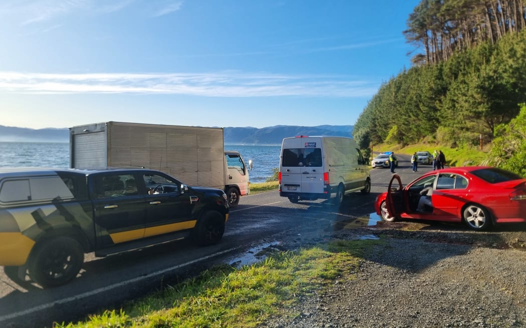 Transport vans and other vehicles at the police cordon blocking the road to the Māhanga Bay occupation.