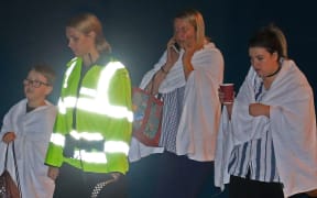 A British police officer escorts walking casualties away from the Manchester Arena stadium in Manchester, United Kingdom on May 23, 2017.