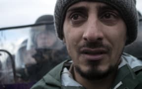 A stranded refugee reacts during clashes between refugees and police at the Macedonia-Greece border