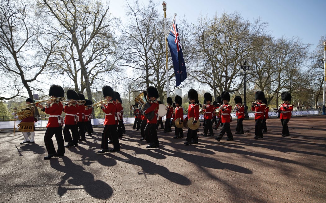 Members of the British Regimental Band marches beneath the NZ flag on the road to Buckingham Palace