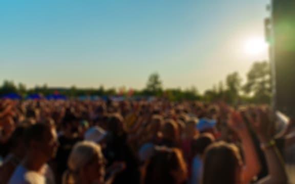 People watching music concert on large stage. Blurred image. Festival
