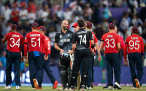 Daryl Mitchell (C) and team mate Mitchell Santner of the New Zealand BlackCaps celebrate as players from England walk off the ground after the ICC Men's T20 World Cup semifinal between New Zealand and England at Sheikh Zayed Cricket Stadium, Abu Dhabi, UAE on 10 November 2021.