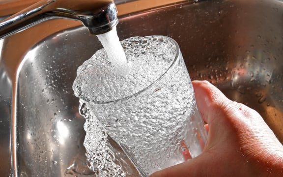 Tap water pouring into a glass.