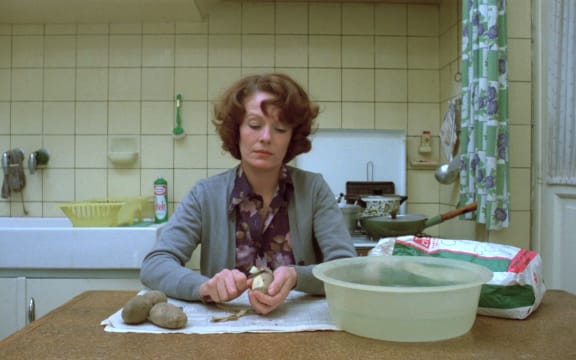 Delphine Seyrig as Jeanne Dielman peels potatoes for dinner on Day One of Jeanne Dielman, 23 quai du Commerce, 1080 Bruxelles (Chantal Akerman).