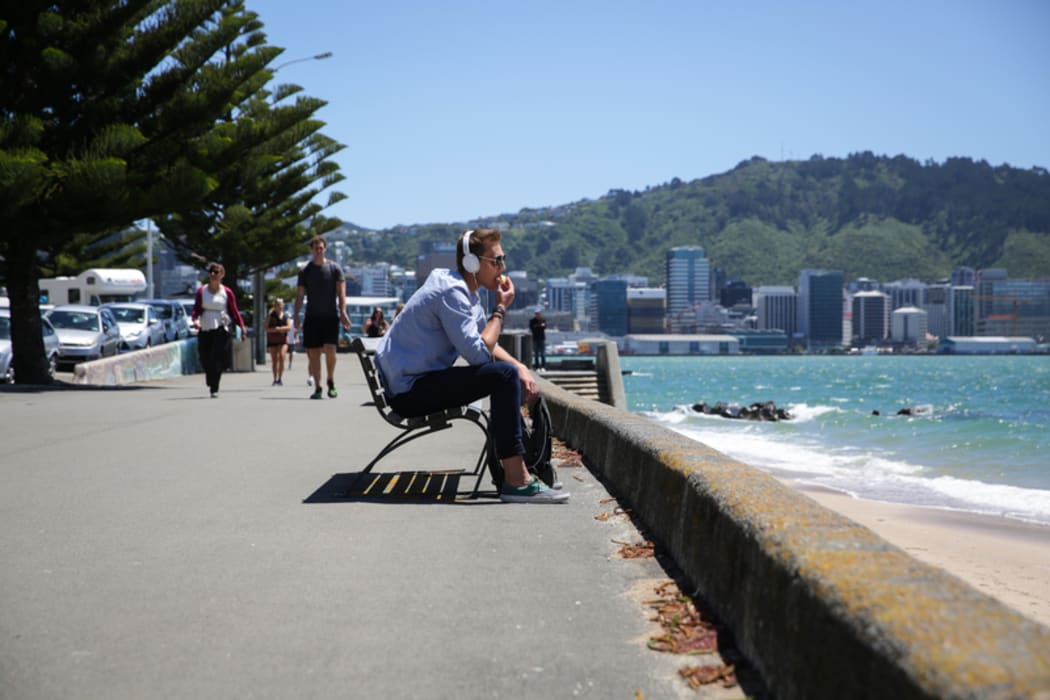 Oriental Parade after the weather bomb, a man enjoys the sunshine after heavy rain and high winds