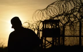 A US soldier walks next to a razor wire-topped fence at an abandoned detention facility at the US Naval Station in Guantanamo Bay (file).