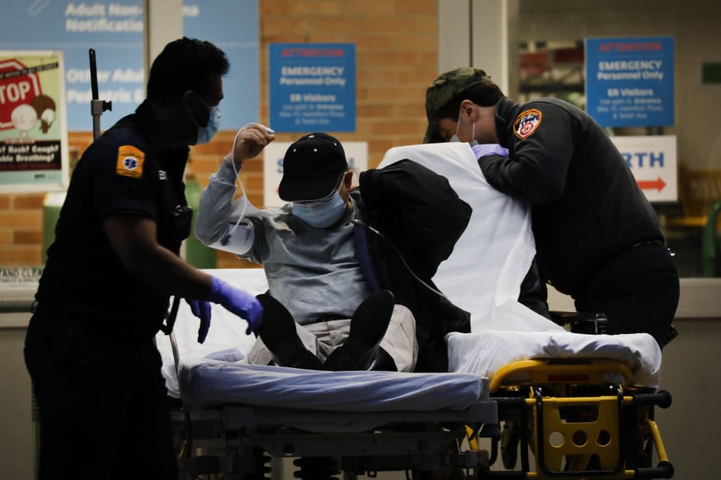 Medical workers bring in patients at a special coronavirus intake tent at a Brooklyn medical centre.