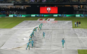 Groundsmen remove the covers from the pitch after a rain shower during the first Twenty20 international cricket match between Pakistan and New Zealand, at the Rawalpindi Cricket Stadium in Rawalpindi, 2024.
