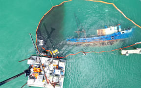 A skimmer cleans spilled oil from Carey Bay in Port Chalmers.