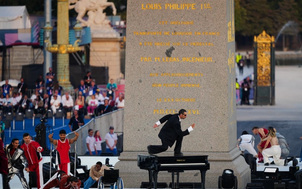 Los bailarines actúan frente al Obelisco de Luxe (Obelisco de Luxor) en la Plaza de la Concordia durante la ceremonia de apertura de los Juegos Paralímpicos París 2024 el 28 de agosto de 2024 en París. (Foto de Dimitar Tilkoff/AFP)