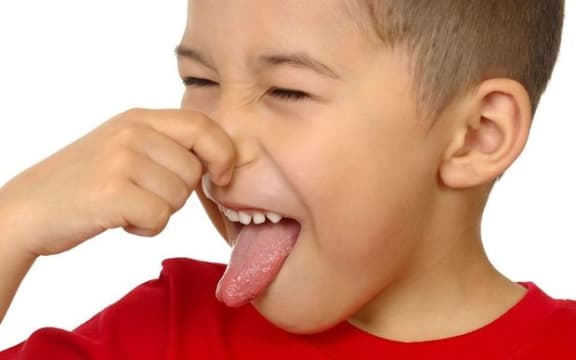 A child holding his nose