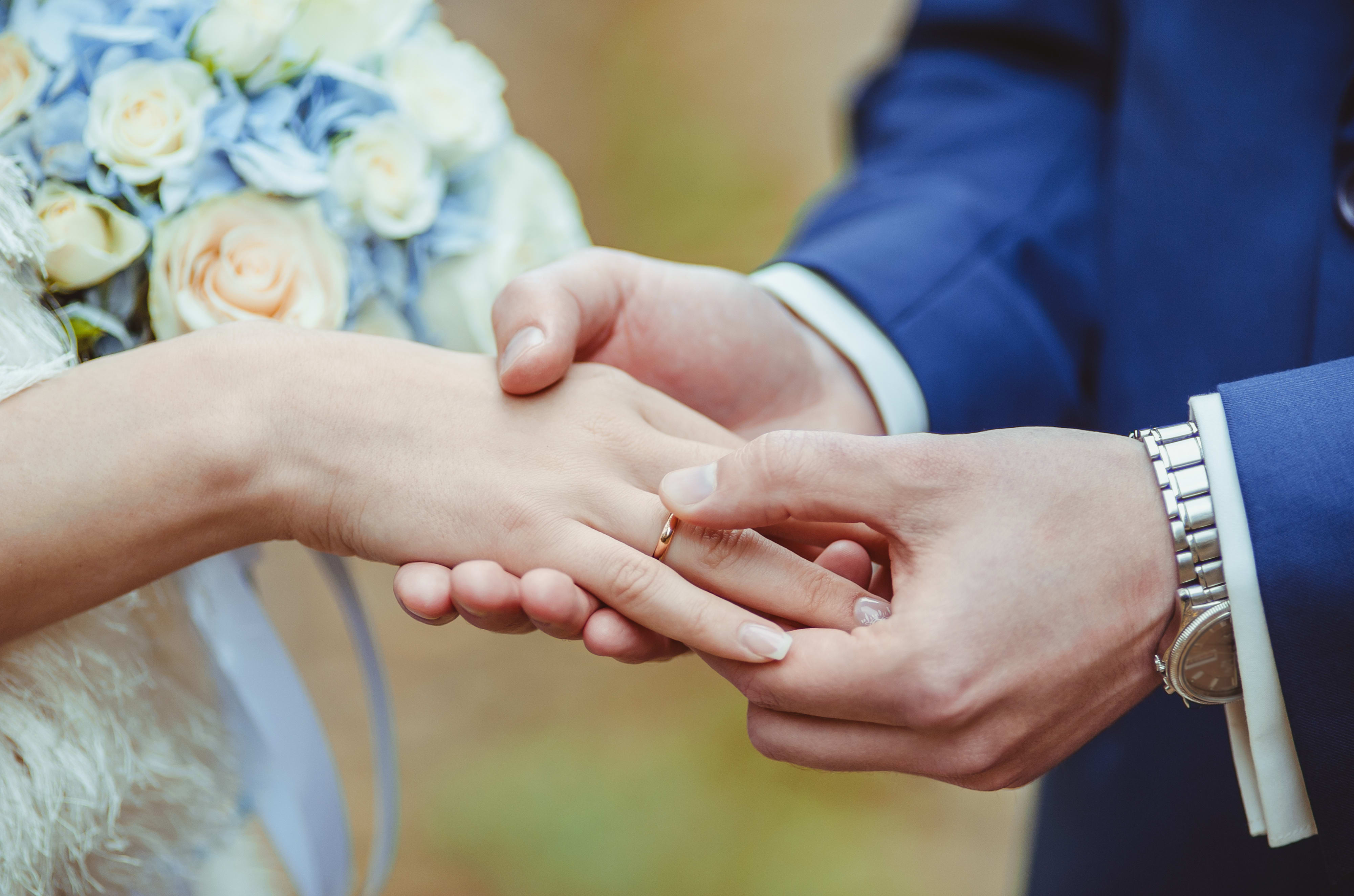 Groom's putting a wedding ring on the bride's finger