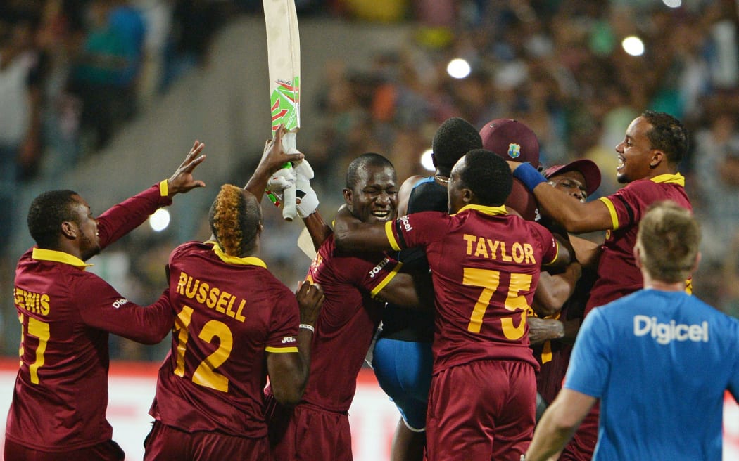 West Indies teamates mob Carlos Braithwaite after their T20 World Cup win.