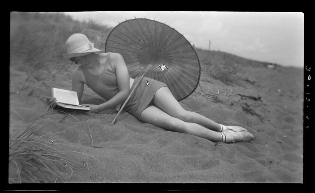 Woman reading at the beach December 1934