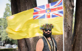 Joseph Tavita Ogotau-Wright holding a Nuien flag at OurMarch in Auckland