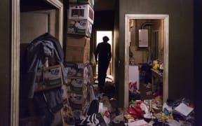A man with diogenes syndrome or compulsive hoarding lives alone in his garbage-filled apartment in the city.
