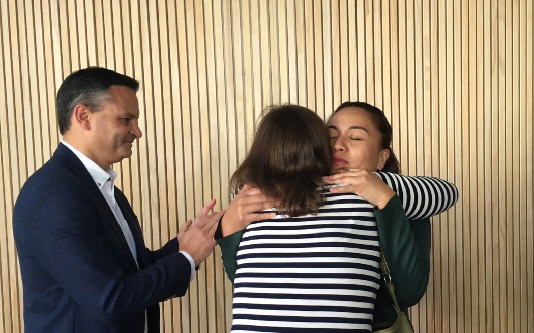 Julie-Anne Genter hugs Marama Davidson while James Shaw looks on