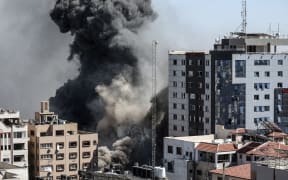 Smoke rises after Israeli forces destroyed a building in Gaza City where Al Jazeera, Associated Press had their offices, on 15 May 2021.