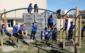 Children play on equipment donated from an Auckland school.